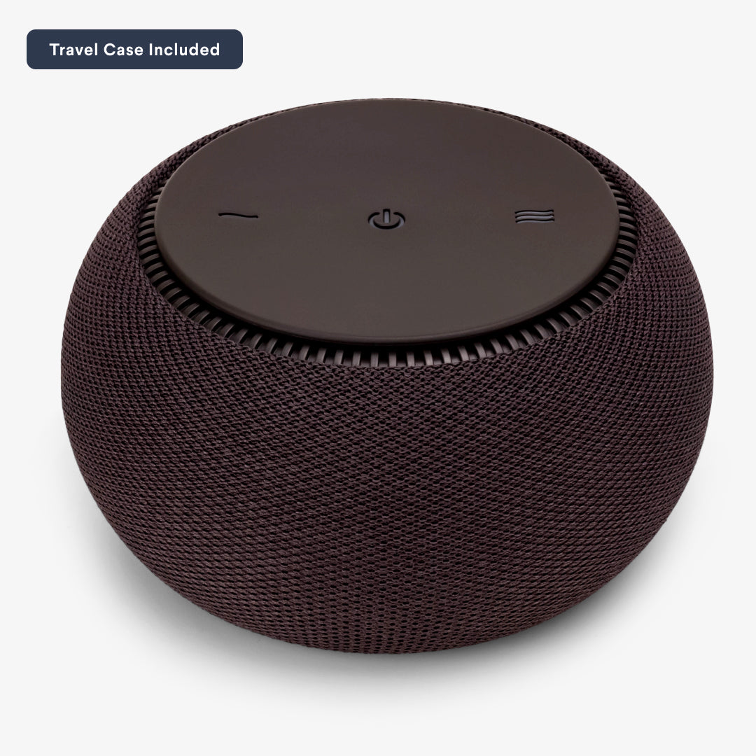 Portable wireless speaker with fabric cover and power button on top.